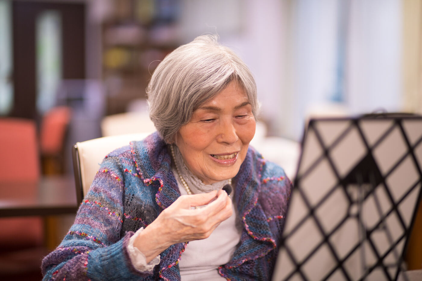 An older woman painting confidently at an easel