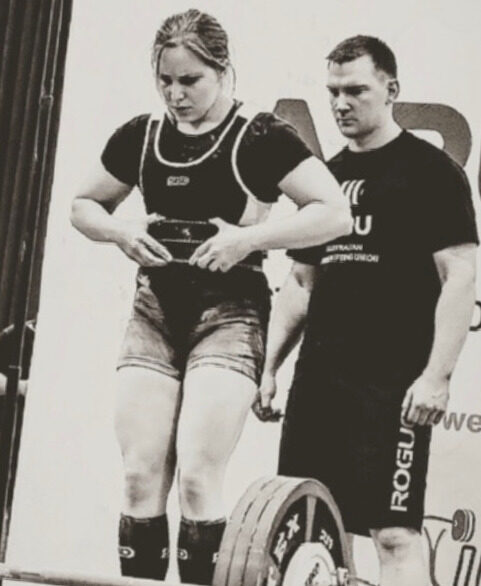 Two lifters preparing on the competition platform