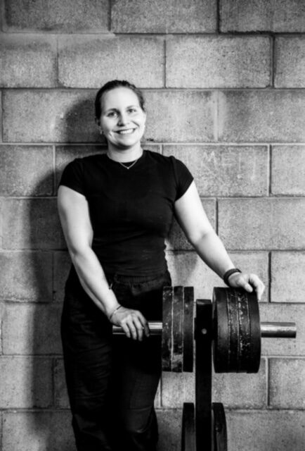 Hannah Altman leaning on a stack of weight plates